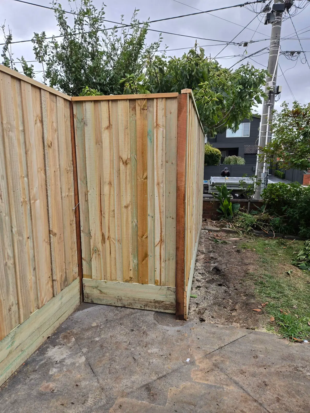 Detail of a capped paling fence corner with an exposed hardwood post