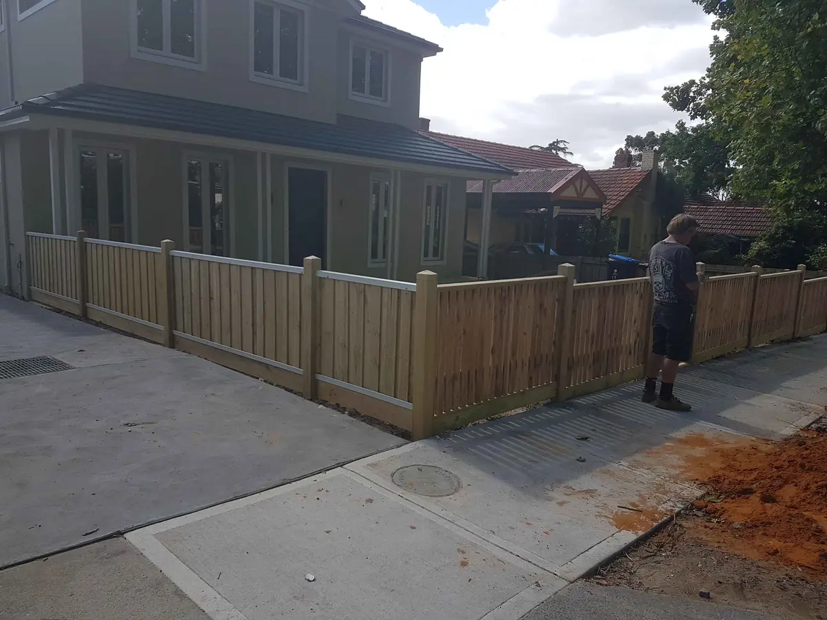 Capped timber picket front fence wrapping the corner of a new two-storey home