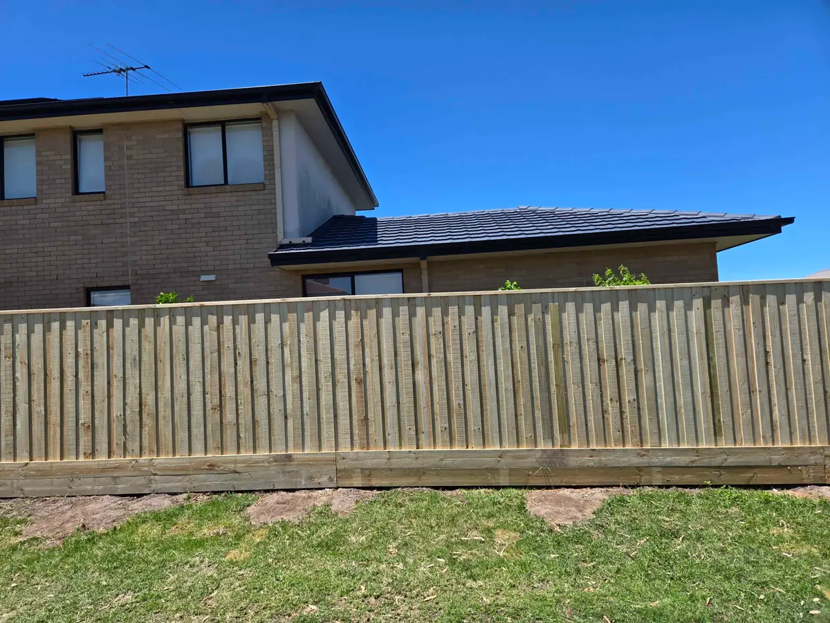 Capped treated pine paling fence with a double plinth along a rear boundary