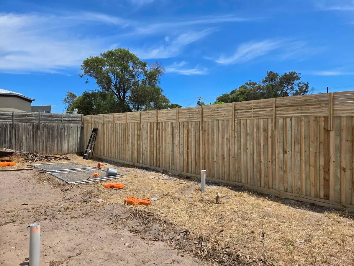 Treated pine paling fence with a lattice top extension along a new build boundary
