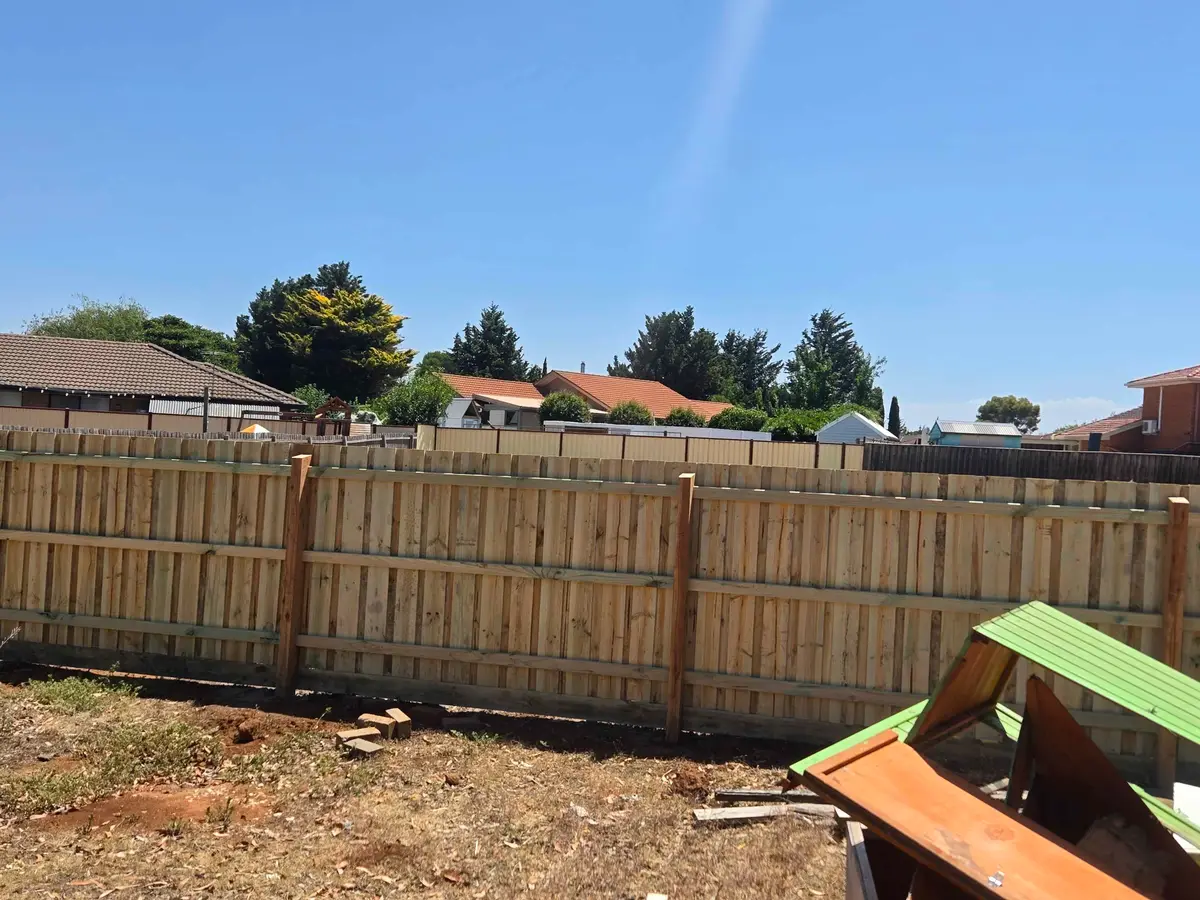 Rear view of a paling fence showing hardwood posts and three rails