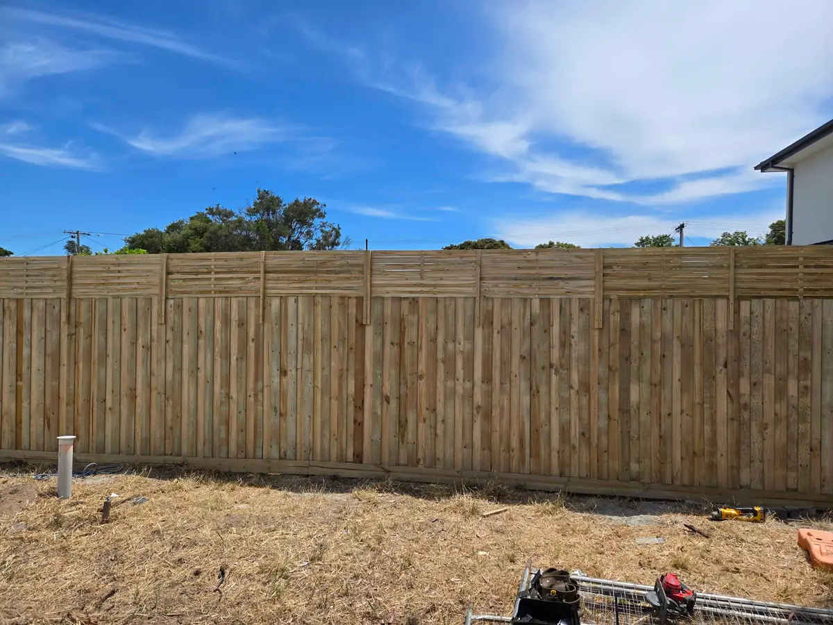 Long paling fence with a timber lattice top running along a rear boundary