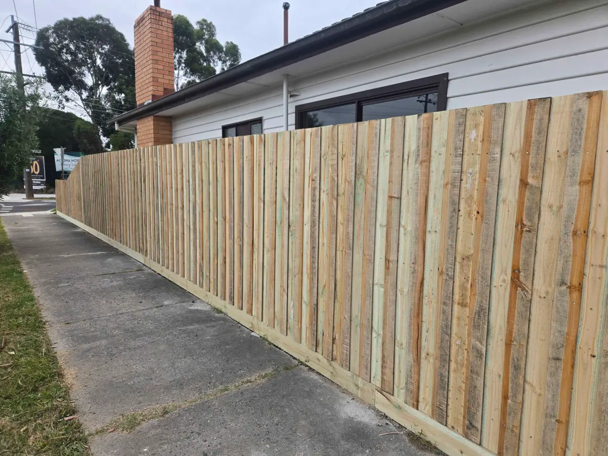 Long treated pine paling fence running along a footpath side boundary